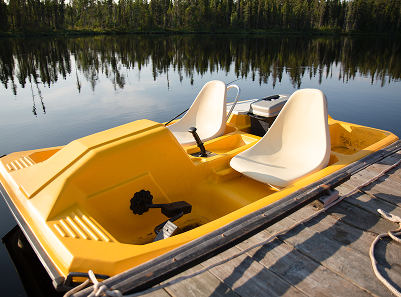A photo of a paddle boat in the water next to a pier